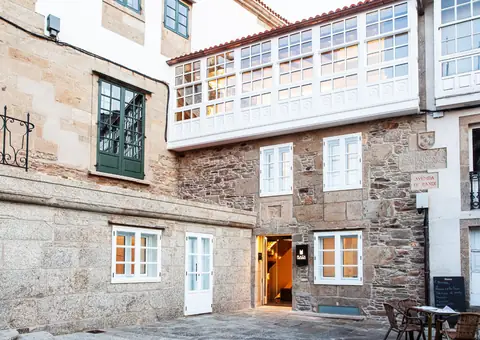 Fachada del hotel con su galería blanca y la entrada
