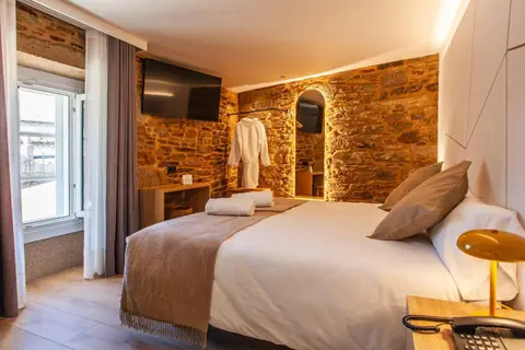 Habitación superior con pared de piedra